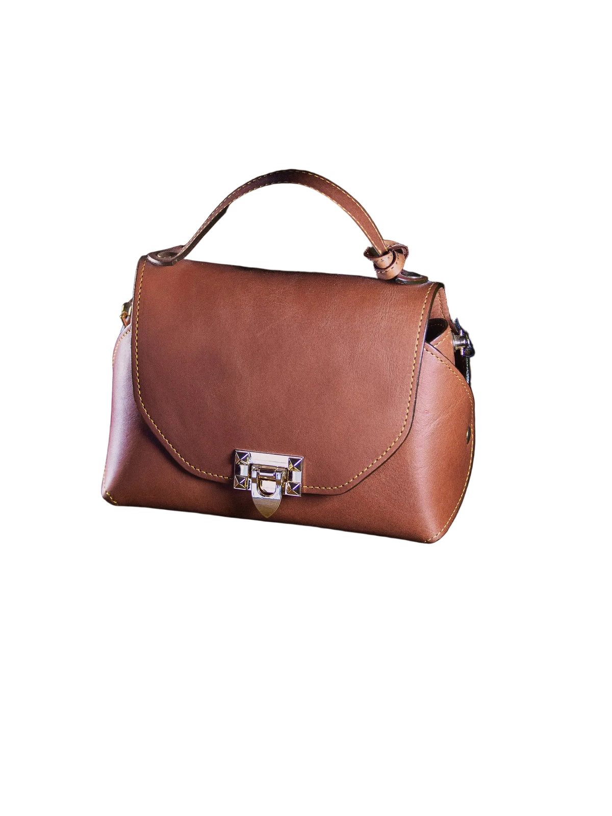 Brown leather handbag on a dark surface with a black background