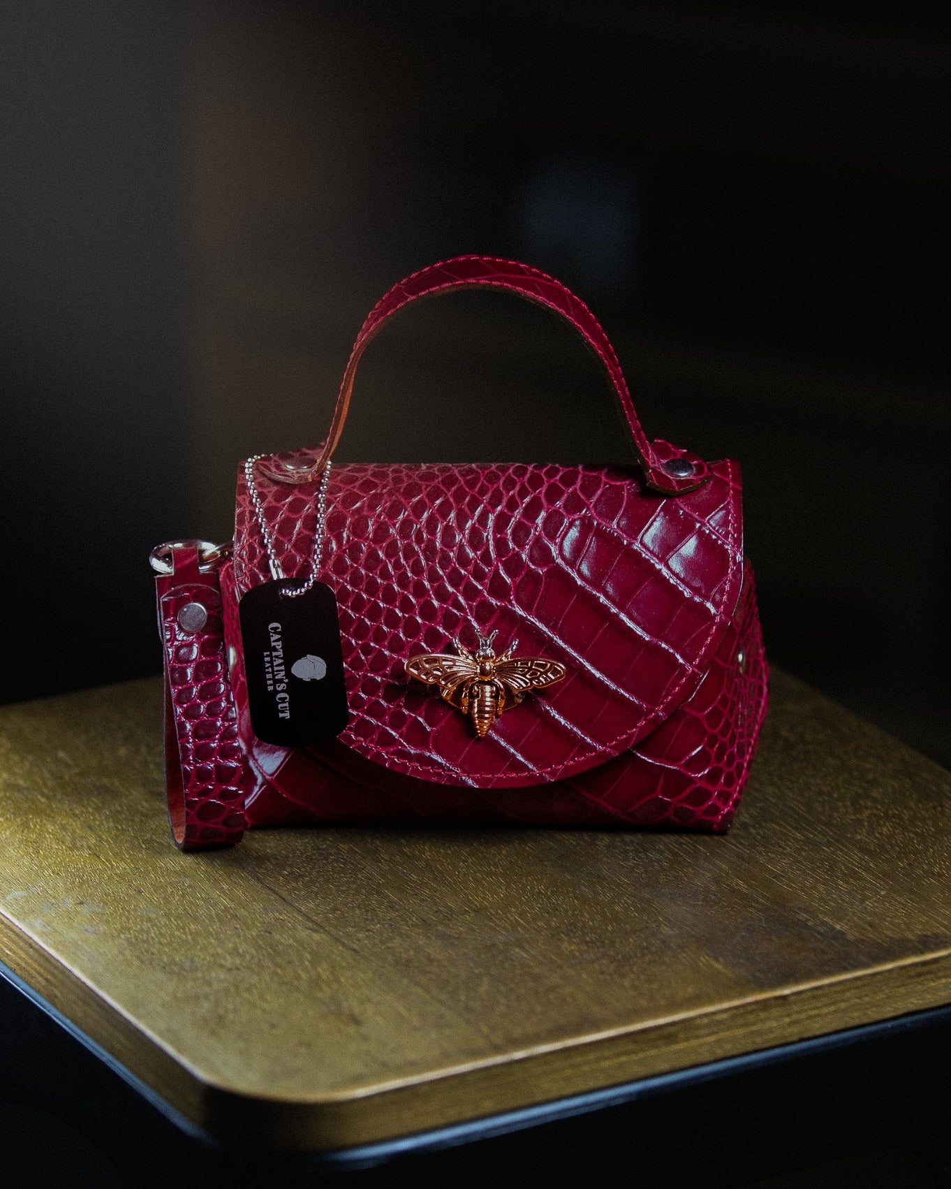 leather micro bag on a wooden surface on a dark background