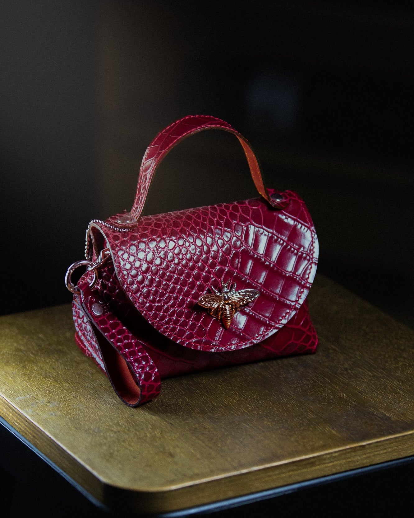 leather micro bag on a wooden surface on a dark background