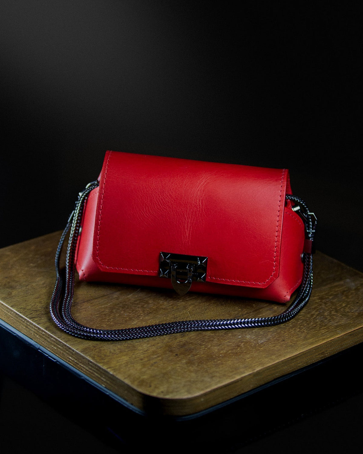 medium leather bag on a wooden surface on a dark background