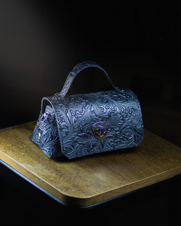 medium leather bag on a wooden surface on a dark background