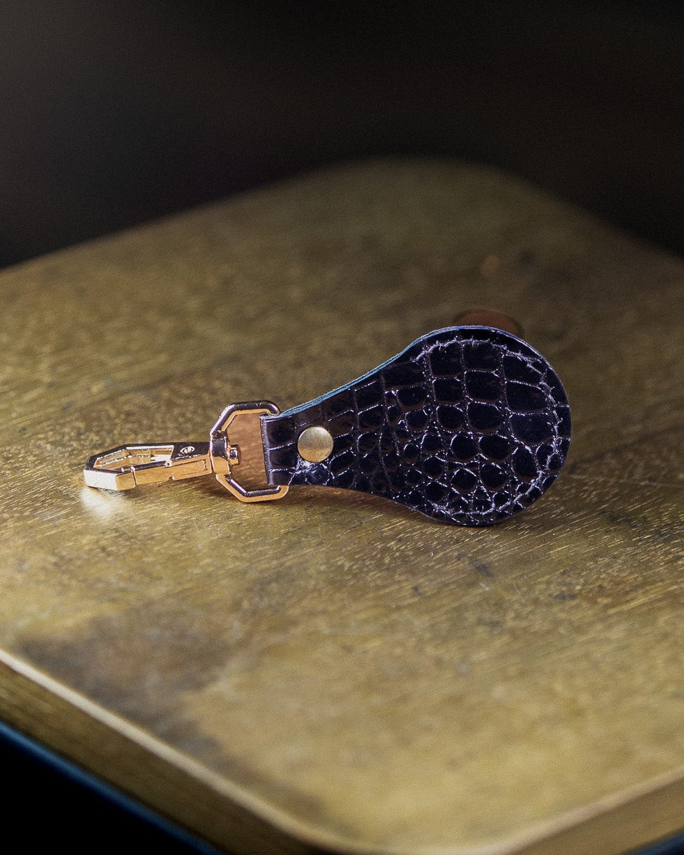 black executive keychain on a wooden surface on a dark background