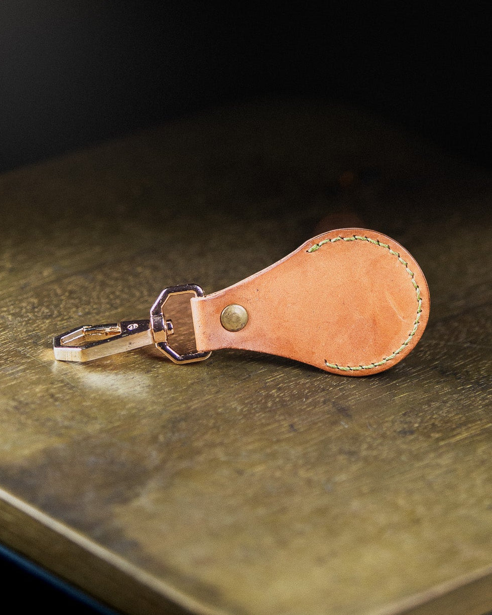 Brown executive keychain on a wooden surface on a dark background