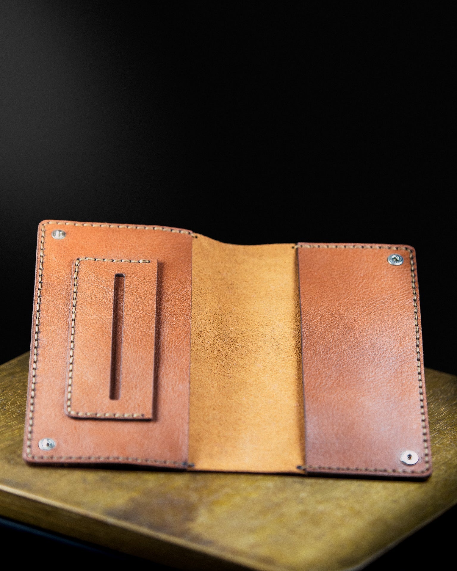 brown leather tobacco pouch on a wooden sourface on a dark background - open