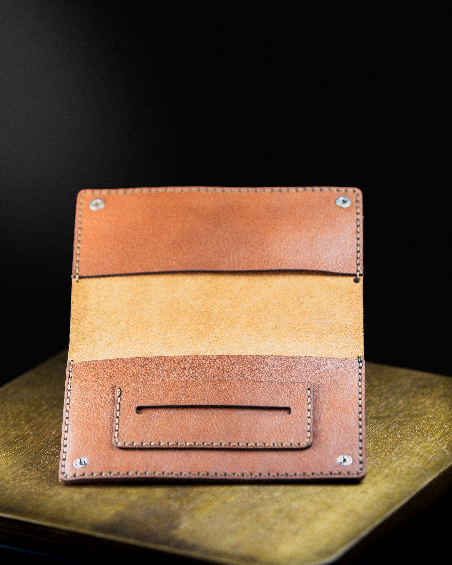 brown leather tobacco pouch on a wooden sourface on a dark background - open