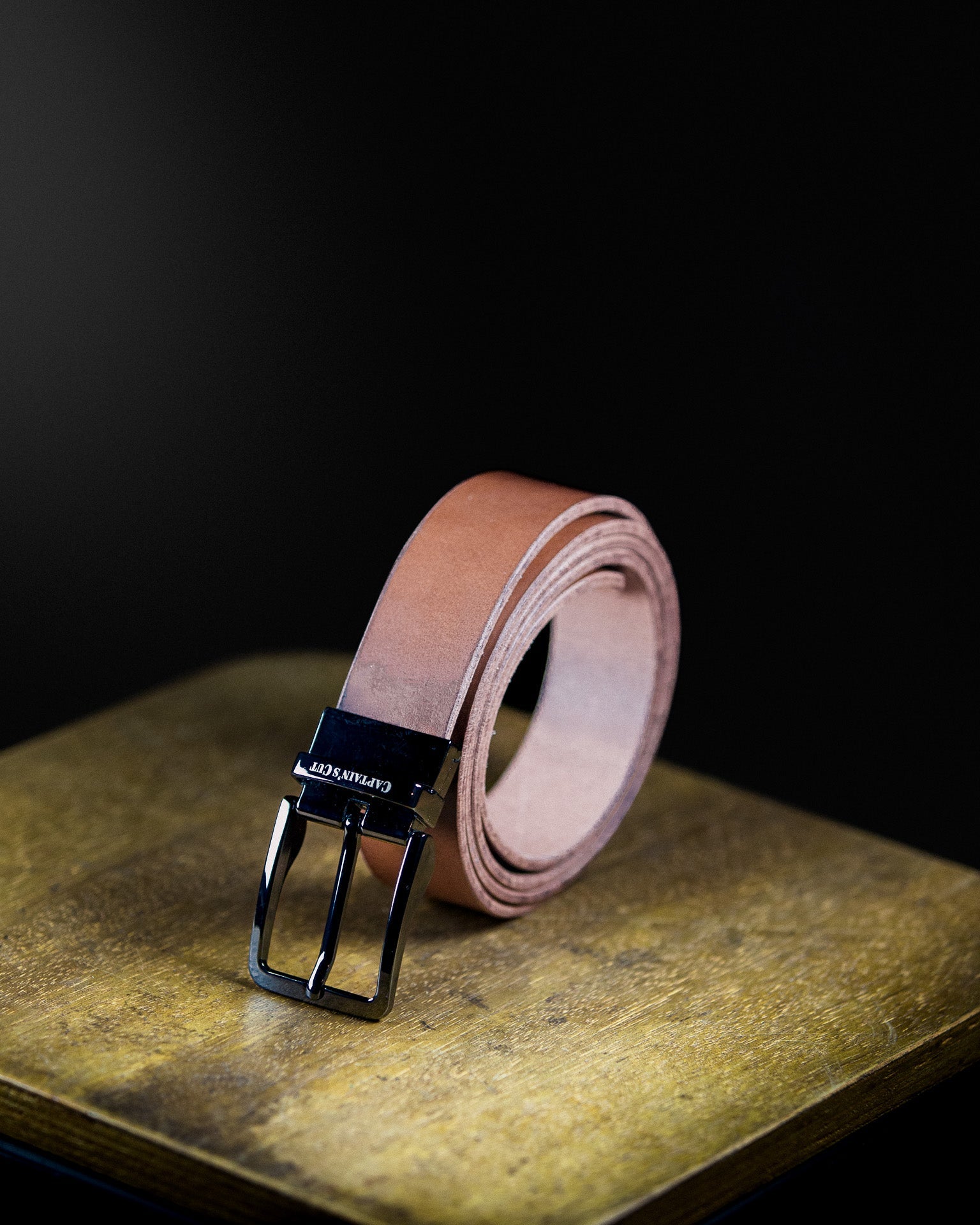 brown leather belt with black metallic buckle
